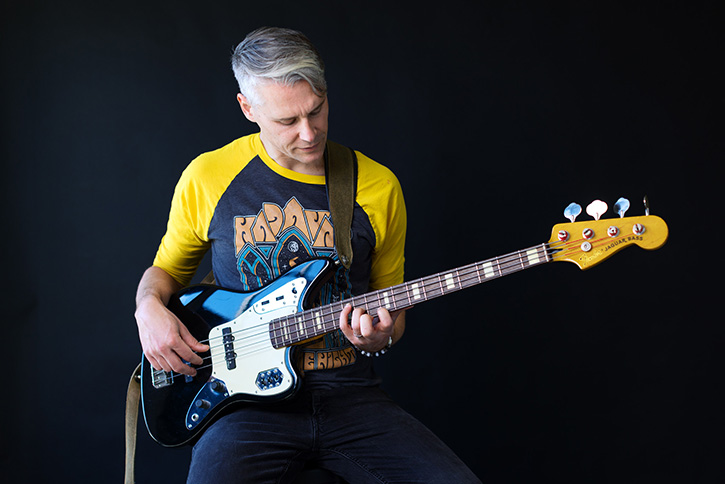 Picture of Gio playing a chord on a bass